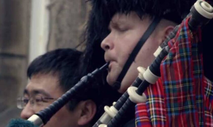 Scottish piper playing the bagpipes on the Royal Mile